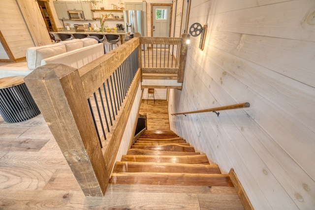 stairs featuring wood walls