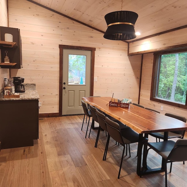 dining area with wood ceiling, wood walls, and a healthy amount of sunlight