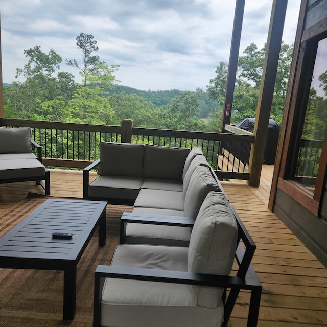 wooden deck featuring a view of trees and an outdoor living space
