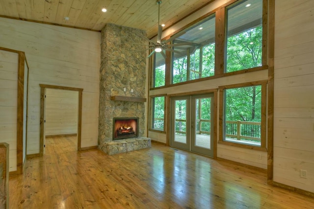 unfurnished living room featuring ceiling fan, wooden ceiling, hardwood / wood-style floors, and a fireplace