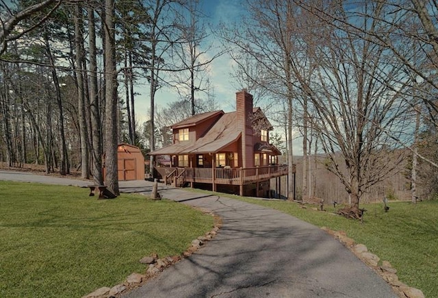 exterior space with a yard, an outbuilding, a chimney, and a shed