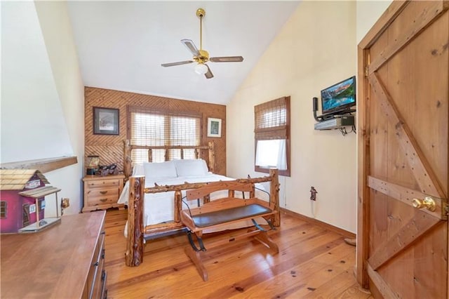 bedroom with high vaulted ceiling and light wood-style flooring