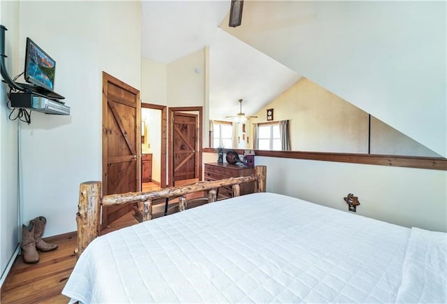 bedroom featuring baseboards, wood finished floors, and vaulted ceiling