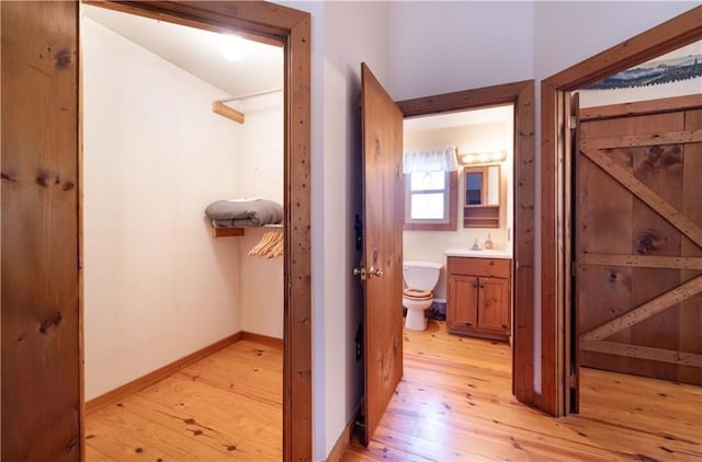 corridor with light wood-style flooring and baseboards