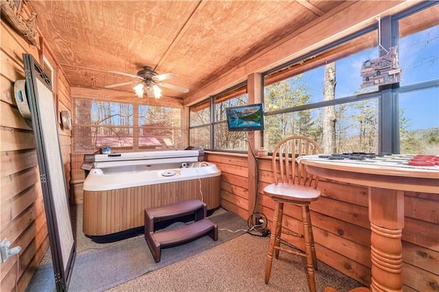 sunroom with a jacuzzi, wood ceiling, and a healthy amount of sunlight