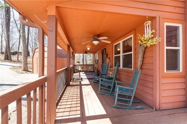 wooden terrace with a porch and a ceiling fan