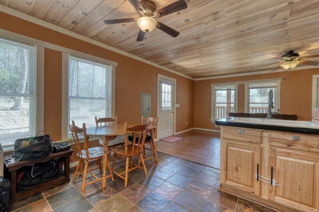 dining area featuring wood ceiling, ornamental molding, a ceiling fan, and stone tile flooring