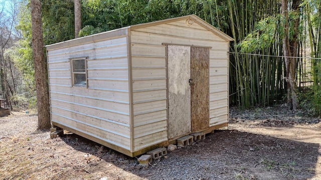 view of shed featuring a view of trees and fence
