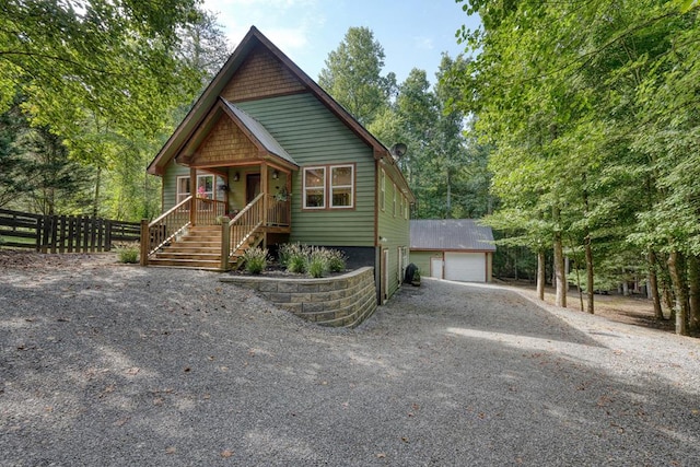 view of front of house featuring covered porch, a garage, and an outdoor structure