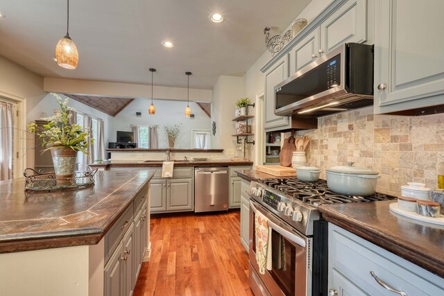 kitchen featuring stainless steel appliances, light hardwood / wood-style flooring, and gray cabinetry