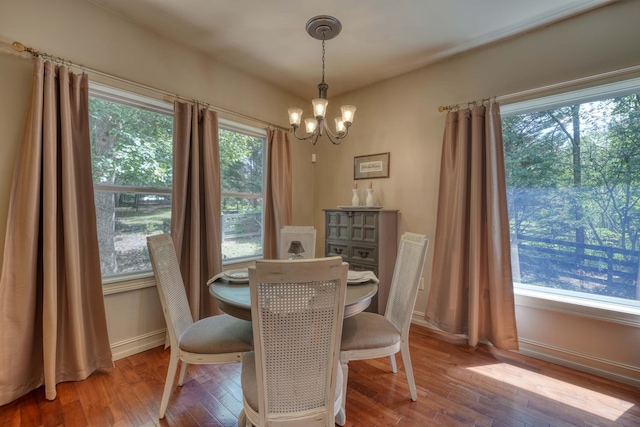 dining space featuring hardwood / wood-style floors, a wealth of natural light, and an inviting chandelier