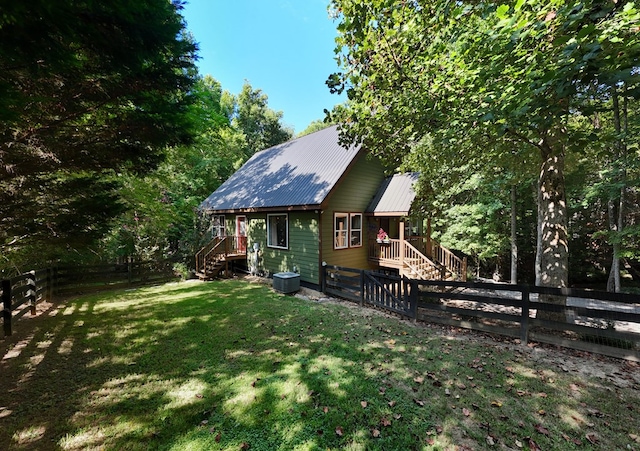 exterior space with central AC and a yard