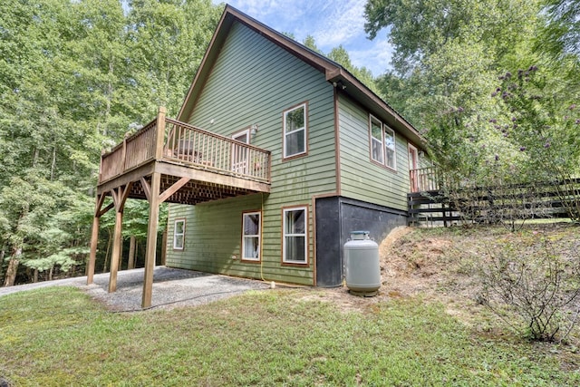 exterior space featuring a patio, a deck, and a lawn