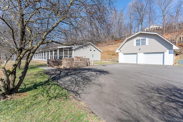 view of side of property featuring a garage and a sunroom