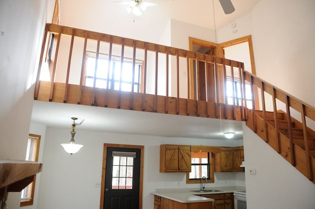 kitchen with pendant lighting, ceiling fan, white range, and sink