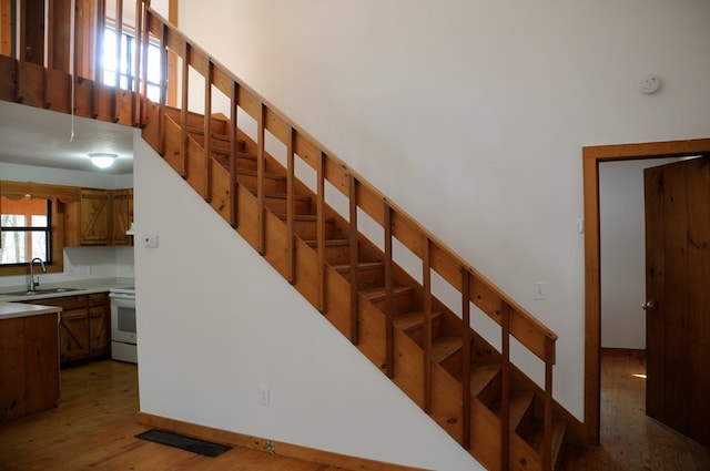 stairs with hardwood / wood-style flooring and sink