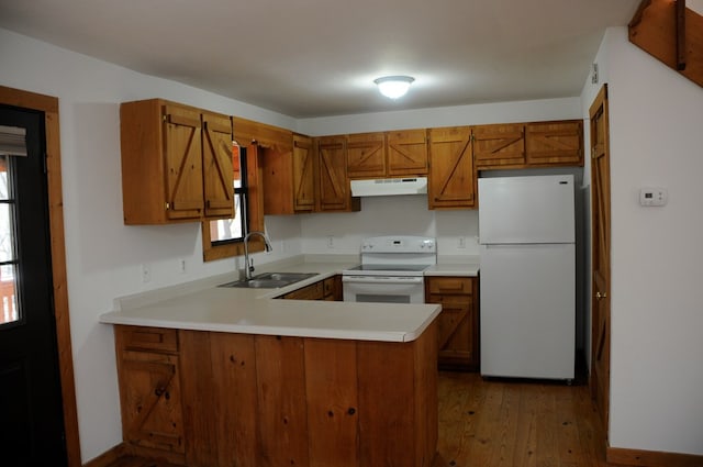 kitchen featuring kitchen peninsula, dark hardwood / wood-style floors, white appliances, and sink