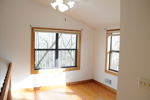 unfurnished dining area with a healthy amount of sunlight, vaulted ceiling, and hardwood / wood-style flooring