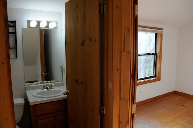 bathroom featuring hardwood / wood-style flooring, vanity, and toilet