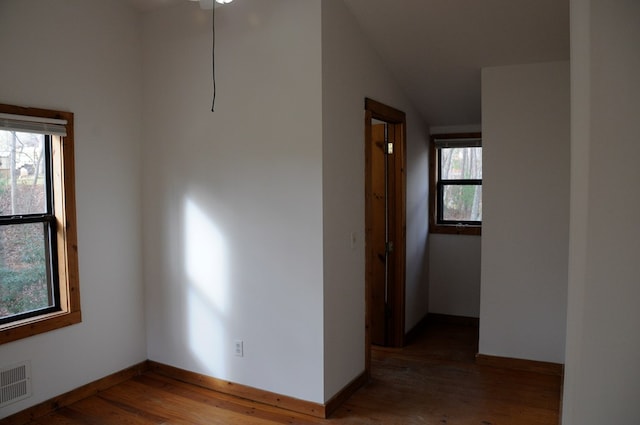 spare room with hardwood / wood-style flooring and lofted ceiling