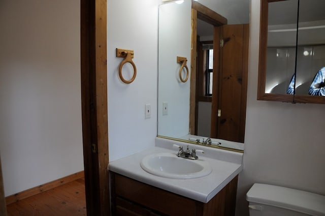 bathroom featuring hardwood / wood-style flooring, vanity, and toilet