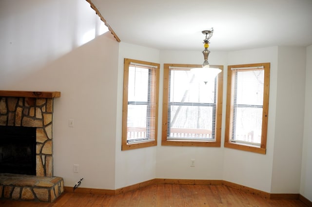 living room with a stone fireplace and wood-type flooring