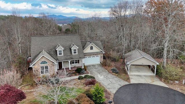 cape cod house with a mountain view, a porch, and a garage