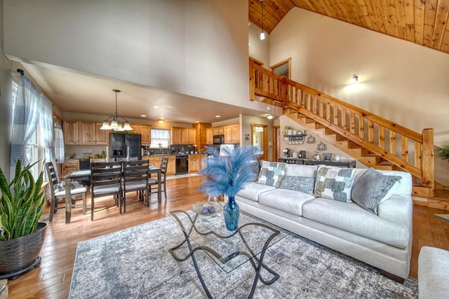 living room featuring wooden ceiling, a notable chandelier, light wood-type flooring, and high vaulted ceiling