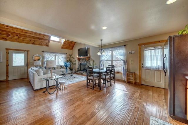 living room with light hardwood / wood-style floors, a fireplace, and a wealth of natural light