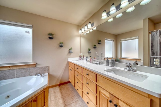 bathroom featuring tile floors, vanity with extensive cabinet space, a washtub, and double sink