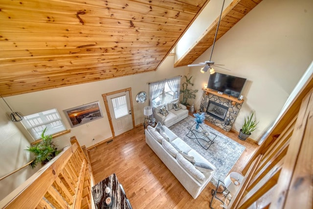 living room with ceiling fan, a fireplace, high vaulted ceiling, light hardwood / wood-style floors, and wooden ceiling