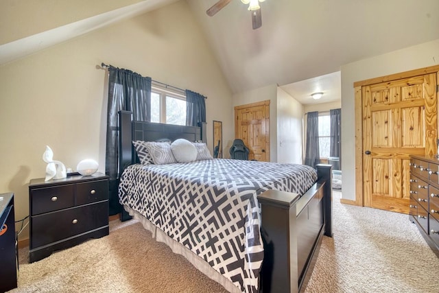 carpeted bedroom with ceiling fan and high vaulted ceiling