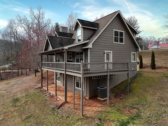 rear view of house featuring a yard and central air condition unit