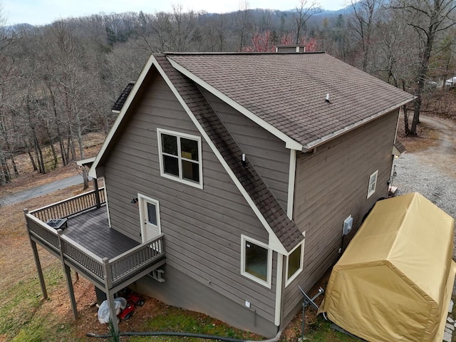 rear view of property featuring a wooden deck