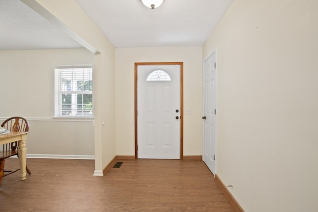 foyer entrance featuring hardwood / wood-style flooring and a textured ceiling