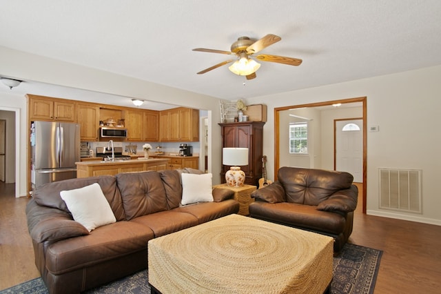 living room featuring a textured ceiling, dark hardwood / wood-style floors, and ceiling fan