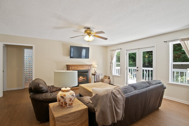 living room featuring french doors, a textured ceiling, light wood-type flooring, and ceiling fan