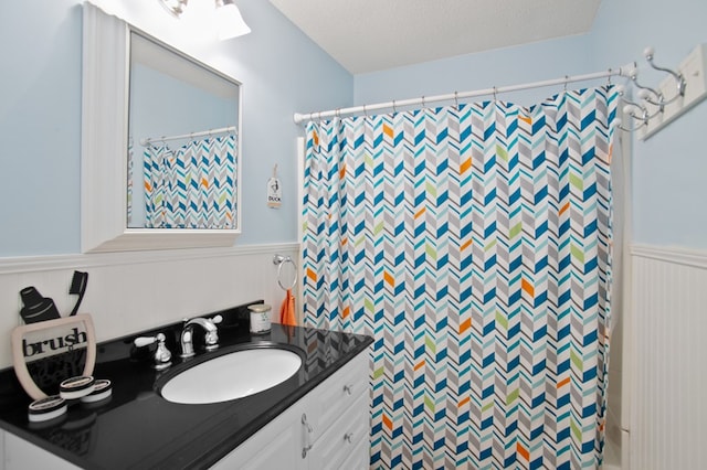 bathroom with vanity, curtained shower, and a textured ceiling