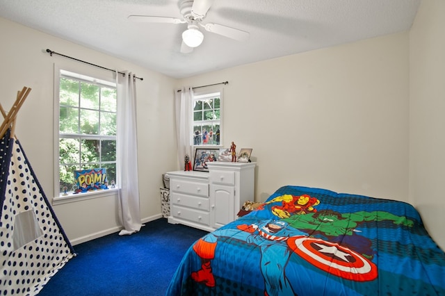 bedroom with dark carpet, a textured ceiling, multiple windows, and ceiling fan