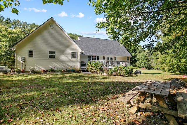 rear view of house with a wooden deck and a yard