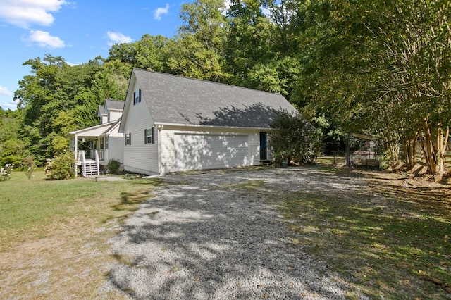 view of property exterior with a garage, a lawn, and a porch