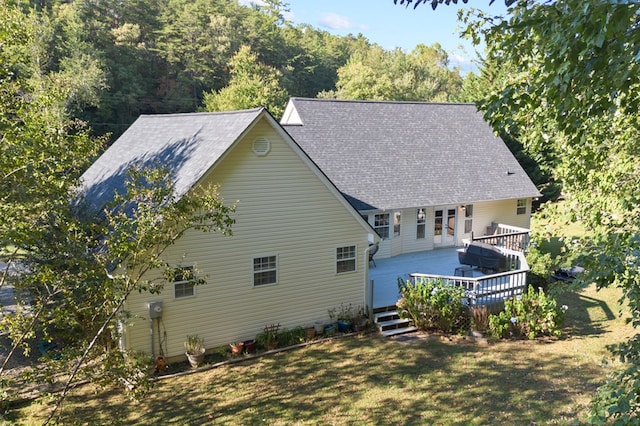 back of property featuring a deck and a yard