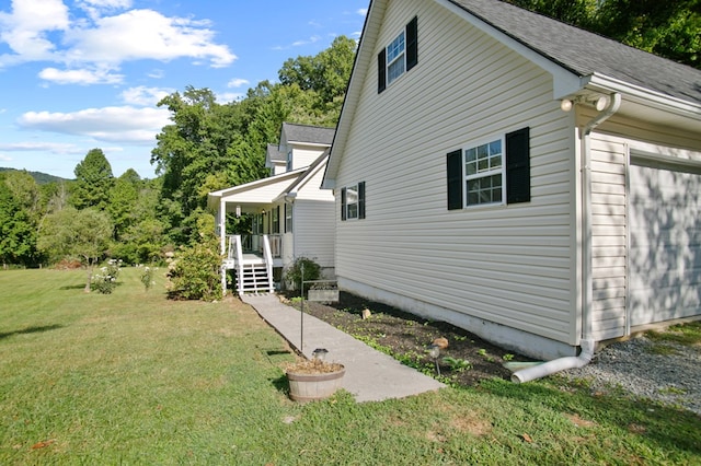 view of home's exterior with a yard, a garage, and covered porch