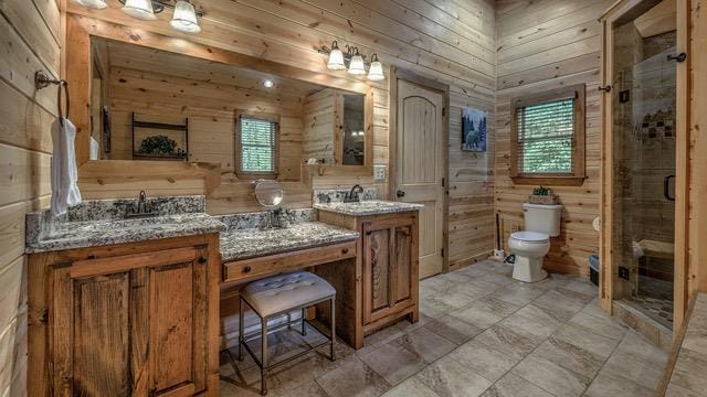 bathroom with vanity, wood walls, toilet, and an enclosed shower