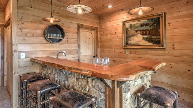 bar with decorative light fixtures and wooden walls