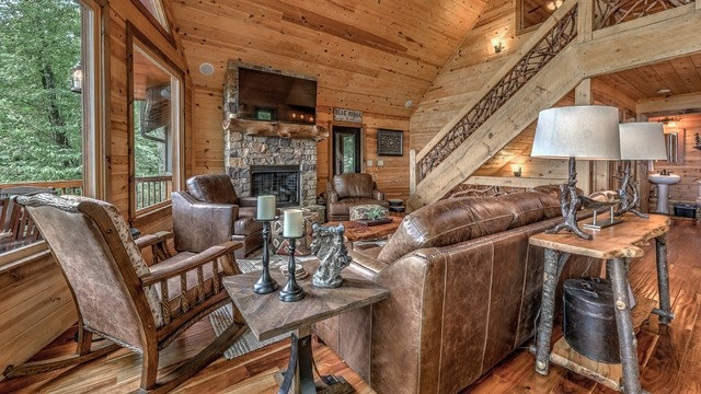 living room featuring wooden ceiling, wood-type flooring, a fireplace, and wooden walls