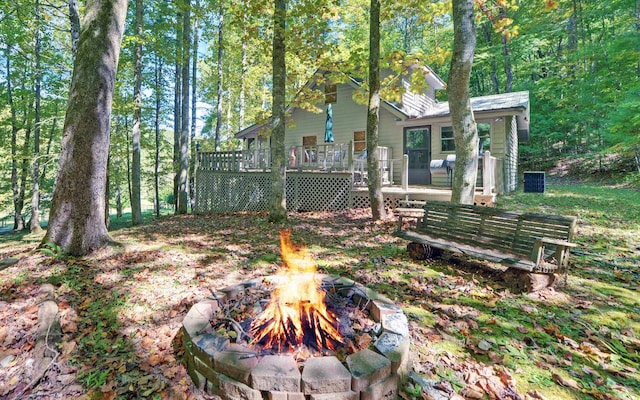 exterior space featuring a wooden deck and an outdoor fire pit