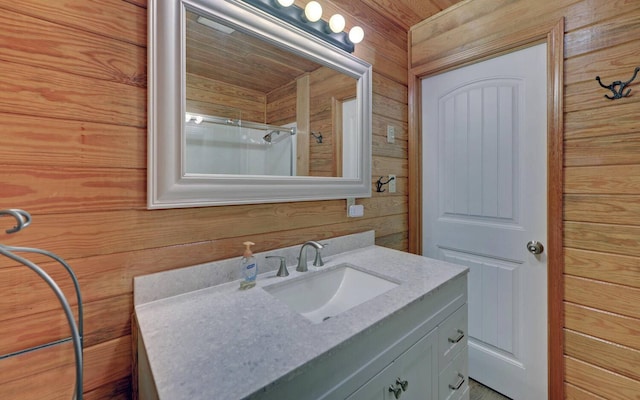 bathroom featuring vanity, walk in shower, and wood walls