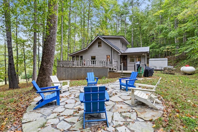 exterior space with a fire pit, a patio area, and a wooden deck