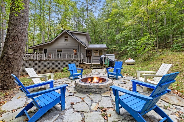 view of patio / terrace featuring a wooden deck and an outdoor fire pit